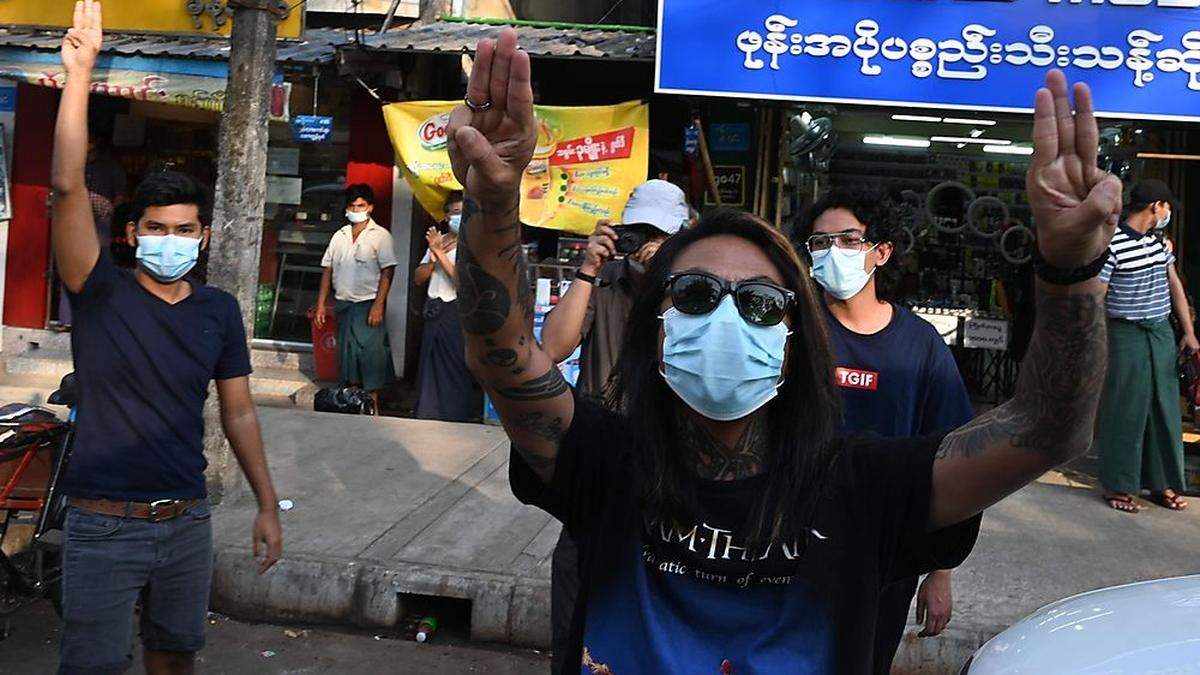 Menschen in Yangon zeigen den Dreifingergruß der Rebellen aus der Science-Fiction-Filmreihe „Die Tribute von Panem“. 