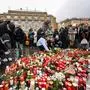 TOPSHOT - People places a candles and flowers at a makeshift memorial for the victims in front of the building of the Philosophical Faculty of the Charles University on December 22, 2023 in Prague, Czech Republic, one day after a mass shooting. The gunman who opened fire at Prague's Charles University killed 13 people and then himself, Czech authorities said, revising the toll from 14 victims. Czech authorities sought a motive in the a student's gun attack at the Charles University's Faculty of Arts. The gunman, a 24-year-old student, died during the attack on December 21, 2023. (Photo by Michal Cizek / AFP)
