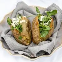 Steirerkrapfen mit Käferbohnen, Cashewcreme, Chimichurri und Barbarakresse zubereitet.