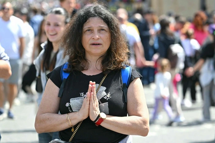 Eine betende Frau auf dem Petersplatz.