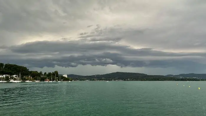 Man sieht dunkle Wolken über einem See