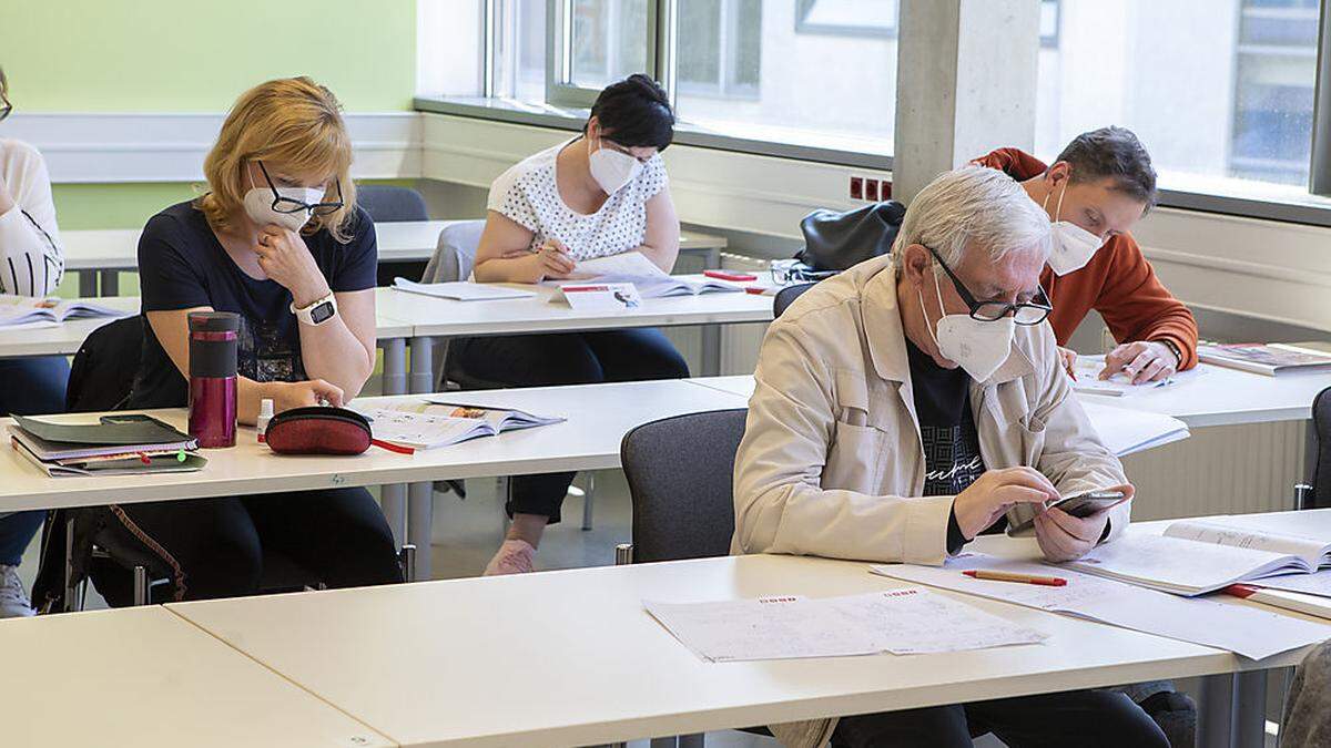 Zwölf Teilnehmer sitzen in einem Kurs