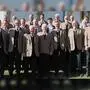 Eine Gruppe Männer in traditionellen Anzügen vor einer Kirche