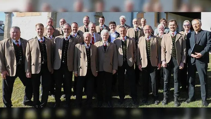 Eine Gruppe Männer in traditionellen Anzügen vor einer Kirche