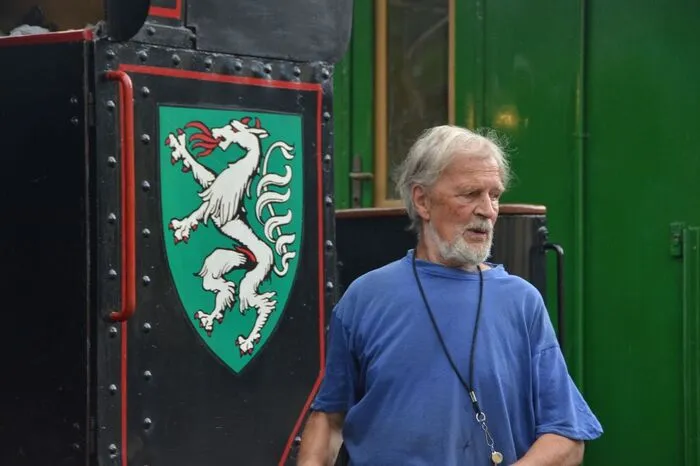 Peter Tschulik, der Wiener Eisenbahnliebhaber, vor dem steirischen Wappen.