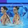 Austria's Anna-Maria Alexandri and Eirini-Marina Alexandri compete in the duet technical routine of artistic swimming at the 2024 Summer Olympics, Friday, Aug. 9, 2024, in Saint-Denis, France. (AP Photo/Lee Jin-man)