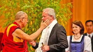 Der Dalai Lama und Gerhard Dörfler stehen auf einer Bühne 