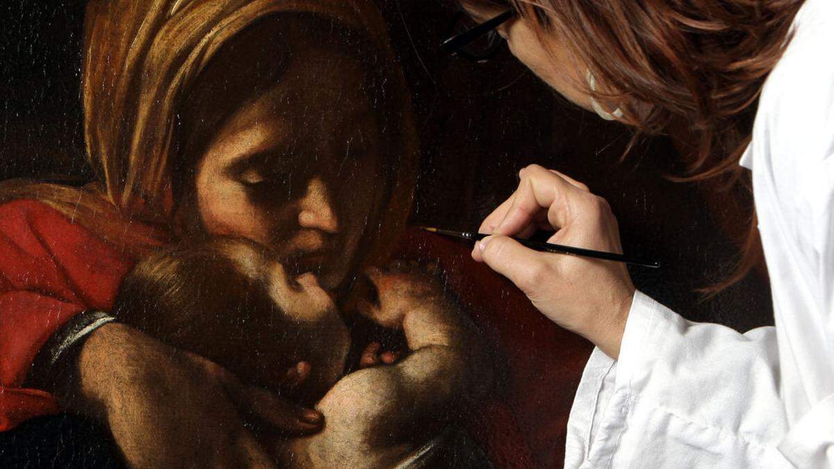 Pinselstrich für Pinselstrich legt eine Restauratorin die leuchtenden Originalfarben eines Weihnachtsbildes von Caravaggio frei