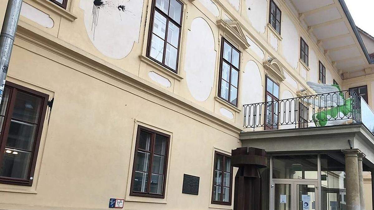 Schwarze Farbspritzer sind auf der Fassade zu sehen.