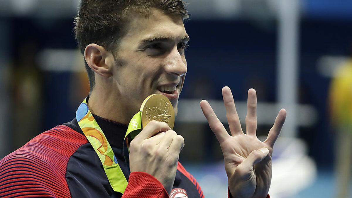 Phelps zeigt es an - es war sein viertes Gold bei diesen Spielen