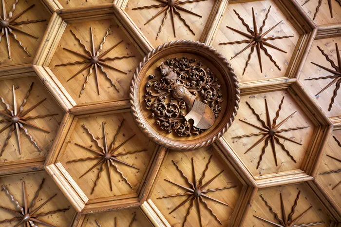 Kunstvoll gefertigte Holzdecke im ersten Stock
