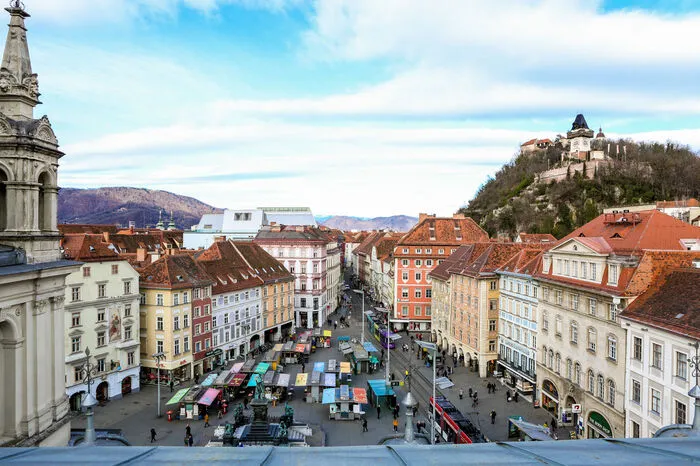 Nach Norden hin breitet sich vor einem der Hauptplatz aus. Die Blicke zieht aber das Grazer Wahrzeichen auf sich: der Uhrturm. Auch gut sichtbar: das unfertige Kastner-Dach.