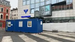 Vor einem Bankgebäude steht ein Baucontainer