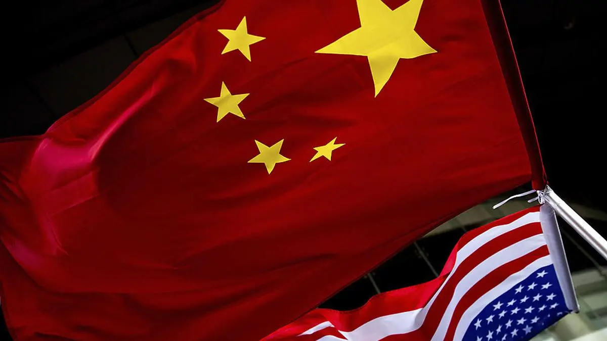 In this Nov. 7, 2012 photo, U.S. and Chinese national flags are hung outside a hotel during the U.S. Presidential election event, organized by the U.S. embassy in Beijing. Government-linked Chinese hackers have intercepted the text messages of thousands of foreigners by penetrating a telecommunications provider and planting eavesdropping software on its servers, the cybersecurity firm FireEye says. (AP Photo/Andy Wong, File)