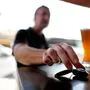 Ein Mann sitzt vor einem Glas Bier und nimmt den Autoschlüssel in die Hand | Selbst wenn man nur wenig Alkohol trinkt und mit dem Auto fährt, riskiert man eine Strafe