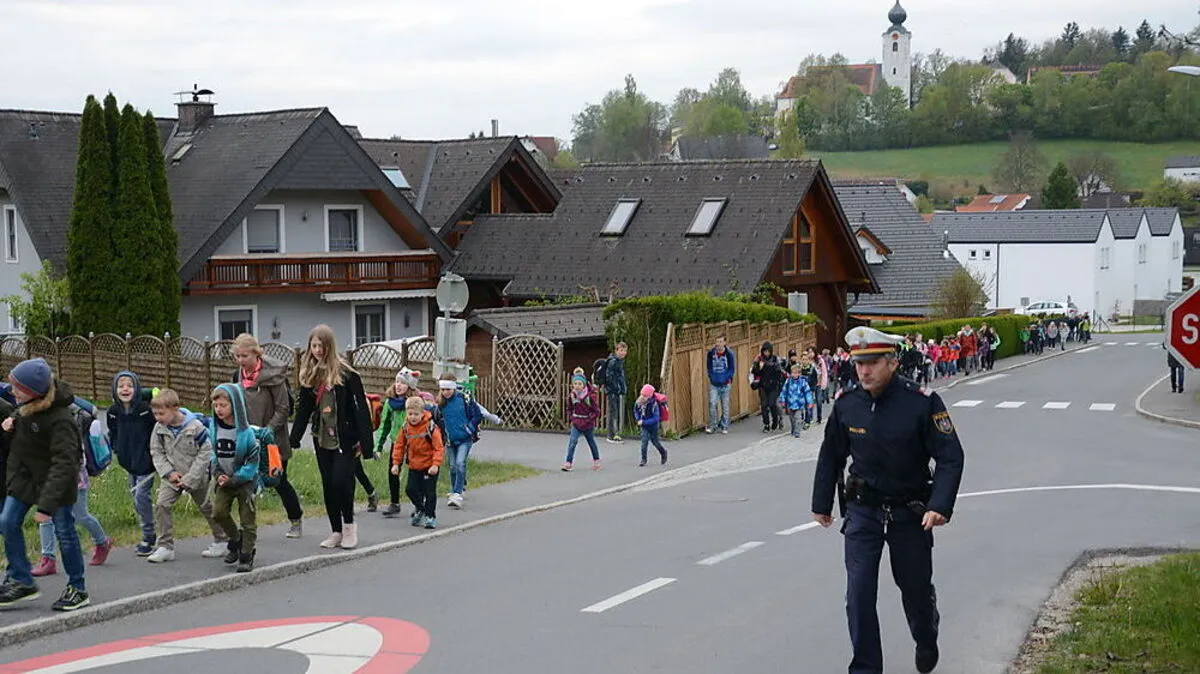 Begleitet von Erwachsenen gehen die Kinder zur Schule