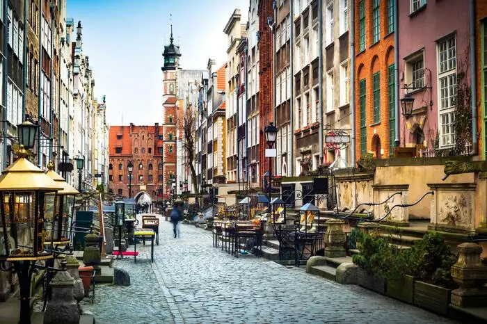 Die Frauengasse. Zwischen der Marienkirche und dem Ufer der Mottlau versteckt sich einer der schönsten Orte von Danzig. Die Frauengasse (Ulica Mariacka) wird flankiert von schmucken Häusern, die durch ihre charakteristischen Treppenaufgänge auffallen. Darauf sitzen als Schlussstücke der Regenrinnen gruselige Gesellen wie Drachen, Löwen oder Seeungeheuer, die einst als Wasserspeier dienten. Heute finden sich in der Frauengasse primär Juweliere, die Schmuck aus Bernstein – dem Gold der Ostsee – verkaufen. Tipp: Pause im Café Drukarnia. Vielleicht auf ein Danziger Goldwasser, ein Kräuterlikör mit echten Goldflocken. 