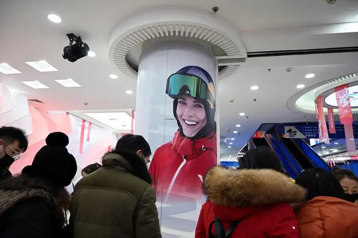 This photo taken on February 7, 2022 shows a portrait of China's gold medallist Gu Ailing Eileen on a column inside a Beijing Winter Olympics souvenir store at the Wangfujing shopping mall complex in Beijing. (Photo by Noel Celis / AFP)