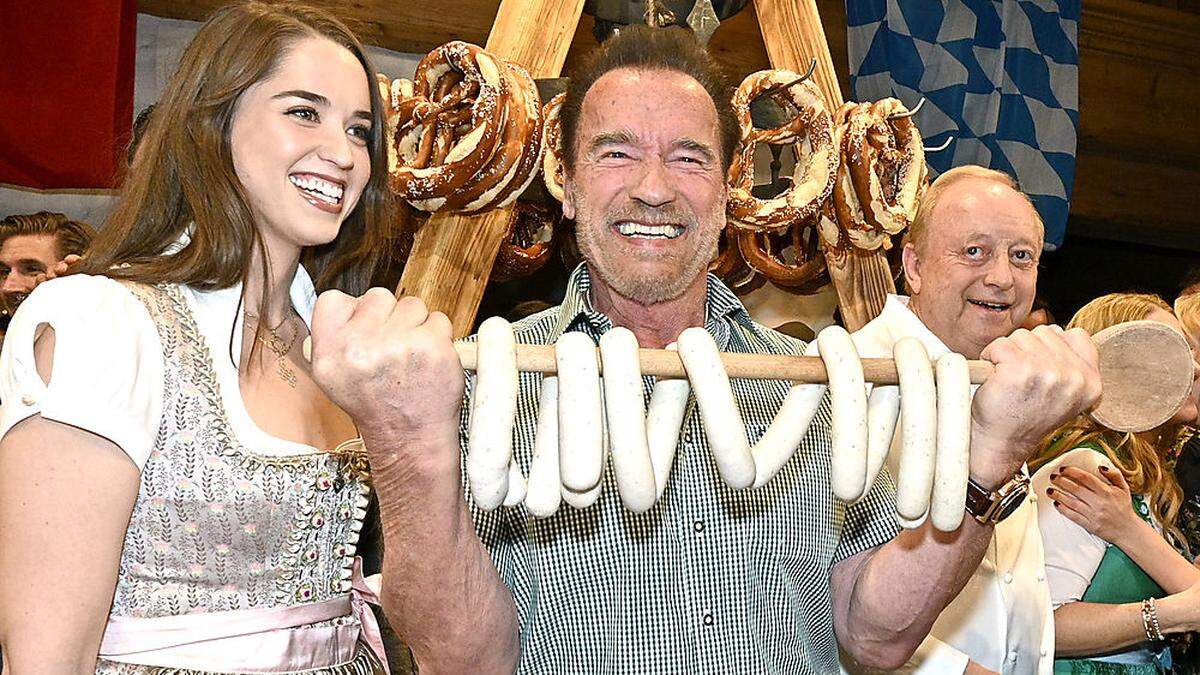 Arnold Schwarzenegger (in der Mitte, links davon seine Tochter Christina) wird heuer bei der Weißwurstparty wieder dabei sein, Starkoch Alfons Schuhbeck (rechts) hingegen nicht