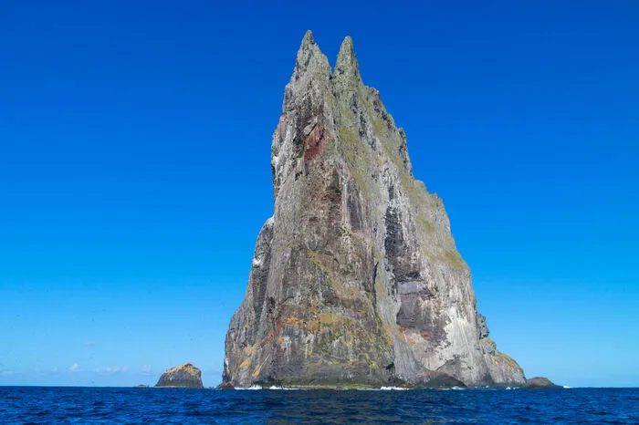 Er kam von einer Insel und fand eine Insel: Der britische Marineoffizier Henry Lidgbird Ball hat im Jahr 1788 diesen Spitz in der Tasmansee entdeckt. Oder besser gesagt: Eigentlich hat er die 20 Kilometer entfernte australische Lord-Howe-Inselgruppe gefunden – der Spitz dahinter war einfach nicht zu übersehen. Stilecht heißt die Felseninsel seitdem auch „Ball’s Pyramid“. Es gibt eine einzige Art von Einheimischen: den Baumhummer. Eine Gespensterschrecke, die eigentlich als ausgestorben galt.