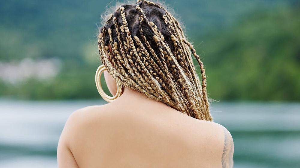 back of a young woman with braided blonde hair and the water of a reservoir in the background Eugi, Navarra, Spain PUBLI