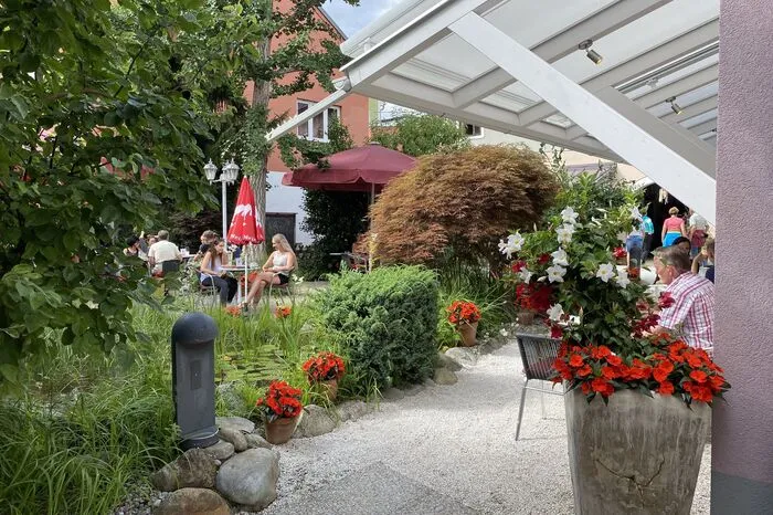 Café Konditorei Moser, Spittal: Das großteils überdachte "Moser-Gart'l" im Zentrum von Spittal ist eine Ruheoase. Den Mittelpunkt bildet ein liebevoll mit Steinen angelegter Naturteich.
