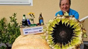 Horst Jöbstl mit Riesensonnenblume und Riesenkürbis, den er ebenfalls kultiviert