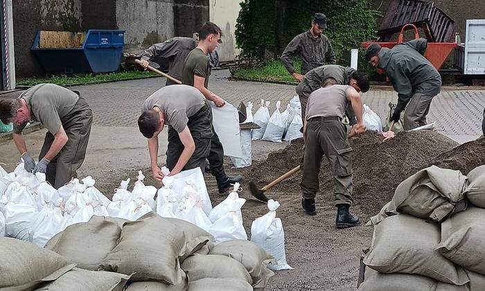 Rund 35 Soldaten füllen Sandsäcke ab