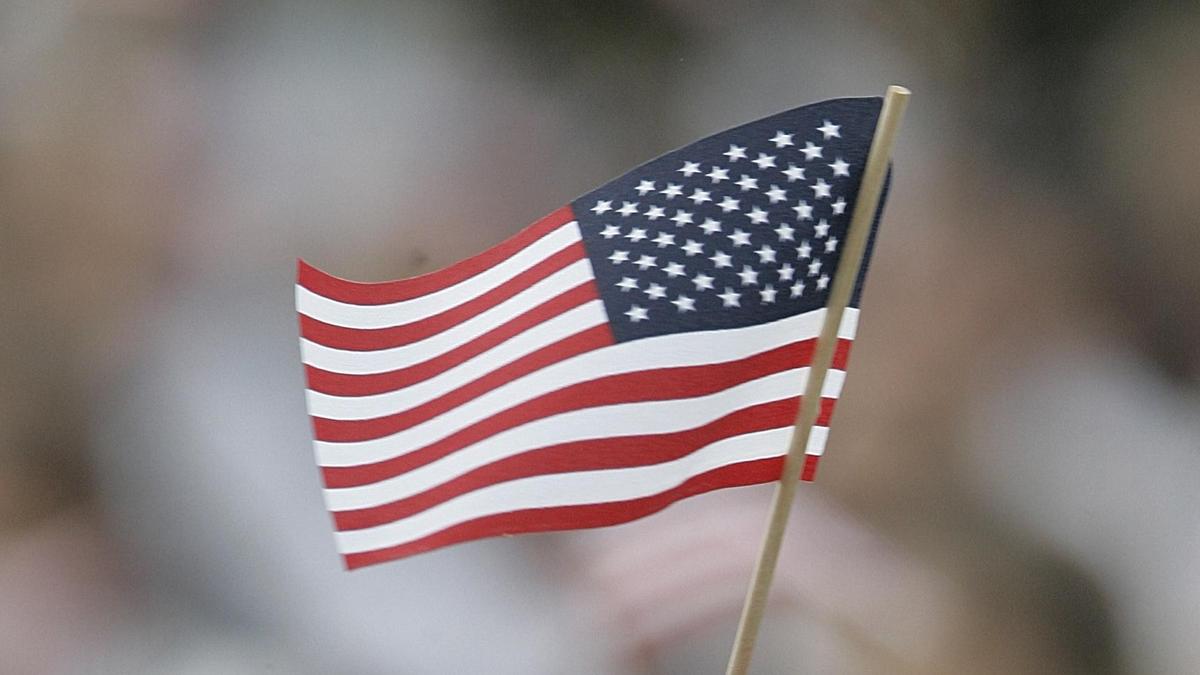 Sujetbild: Die Flagge der USA in der Hand einer dunkelhäutigen Person