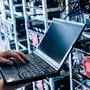 IT specialist working on computer in bitcoin and crypto currency mining farm. Big data center. High tech server computers at work; sujet