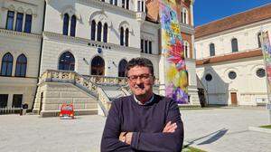 Stadtamtsdirektor Michael Mehsner vor dem neuen Rathaus, vor dem auch eine Fahne zum aktuellen Musikfestival weht: „A Hard Year‘s Spring“