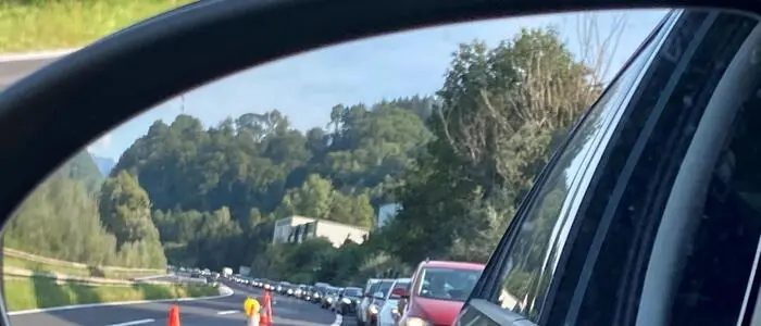 Das Bild zeigt einen Stau im Seitenspiegel eines Autos