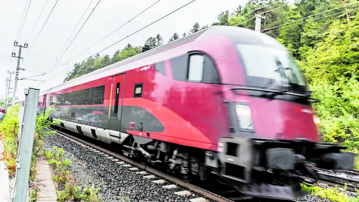 Ein fahrender, roter Zug der ÖBB.