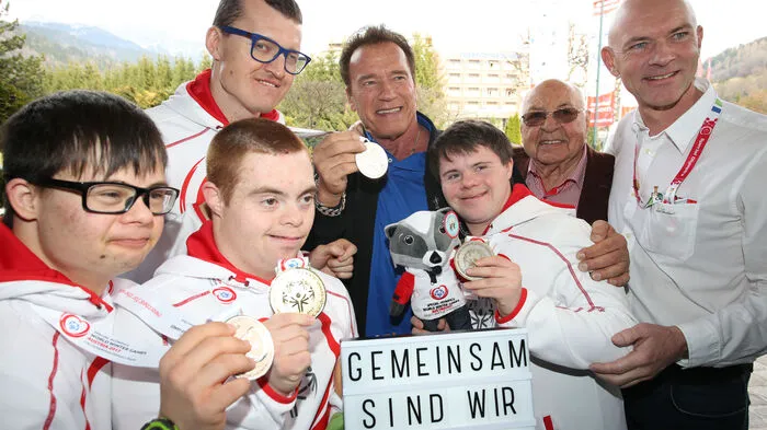 Seine Ankunft ließ die Athleten strahlen: Arnold Schwarzenegger mit vier Sportlern aus der Obersteiermark, Hotelier Ernst Royer und Bürgermeister Jürgen Winter (Schladming).