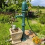 Alter Metallbrunnen in einem Vorgarten