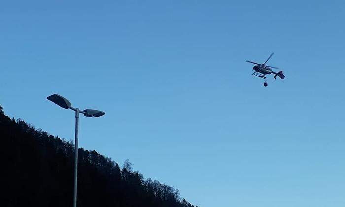 Der Hubschrauber des Innenministeriums fliegt Löschwasser zum Brandort