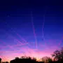 Sonnenuntergang färbt Wolken und Kondensstreifen pink