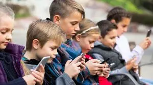 Group of caucasian children posing at urban street with mobile devices
