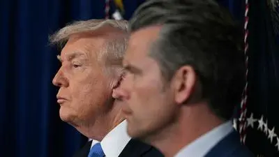 US President Donald Trump and Defense Secretary Pete Hegseth listen to Chairman of the Joint Chiefs of Staff Gen. Dan Caine speak to the press following US military actions in Venezuela, at his Mar-a-Lago residence in Palm Beach, Florida, on January 3, 2026. President Trump said Saturday that US forces had captured Venezuelan leader Nicolas Maduro after launching a "large scale strike" on the South American country. (Photo by Jim WATSON / AFP)