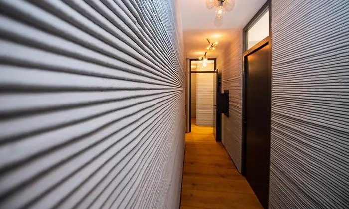 ABD0110_20210726 - BECKUM - DEUTSCHLAND: 26.07.2021, Nordrhein-Westfalen, Beckum: Im Flur des ersten 3D Druckhauses sieht man die mittels eines 3D-Betondrucker aufgetragenen Betonschichten. Die PERI GmbH druckte im nordrhein-westfälischen Beckum das erste Wohnhaus Deutschlands. Das zweigeschossige Einfamilienhaus mit ca. 80 qm Wohnfläche pro Geschoss entstand nicht in herkömmlicher Bauweise, sondern wurde von einem 3D-Betondrucker gedruckt und steht nun in Fertigstellung von Deutschlands erstem in dieser Form gebauten Haus. Foto: Guido Kirchner/dpa +++ dpa-Bildfunk +++. - FOTO: APA/dpa/Guido Kirchner