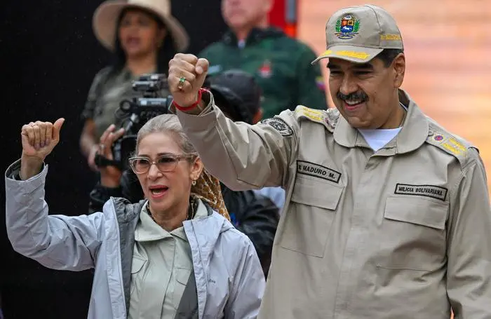 (FILES) Venezuela's President Nicolas Maduro gestures next to First Lady Cilia Flores during an event marking the 165th anniversary of the Battle of Santa Ines in Caracas on December 10, 2024. President Donald Trump said on January 3, 2026, that US forces had captured Venezuelan leader Nicolas Maduro after launching a 
