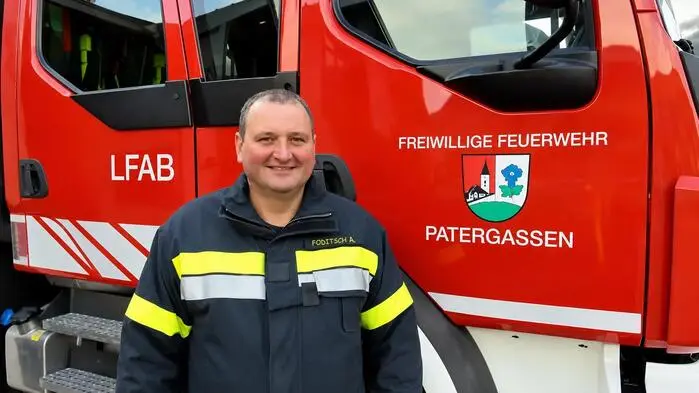 Ein Feuerwehrmann steht vor einem Feuerwehrauto