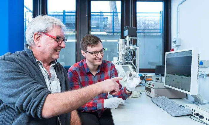 Die Planetologen Prof. Dr. Addi Bischoff (li.) und Markus Patzek mit dem Meteoriten „Flensburg“ vor dem Rasterelektronenmikroskop