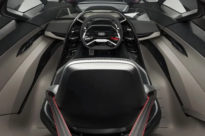 Der PB18 e-tron ist 4,53 Meter lang, 2 Meter breit und nur 1,15 Meter hoch. Der Radstand beträgt 2,70 Meter, die Überhänge fallen kompakt aus. Das Resultat ist nicht nur eine unverwechselbare Silhouette, sondern auch mit 470 Litern ein klares Plus an Raum für Reisegepäck, obwohl dieser Audi der klassischen Architektur eines Mittelmotor-Sportwagens folgt. Ein Mix aus Aluminium, Karbon und Multimaterial-Verbundstoffen sorgt bei der Karosserie für ein niedriges Grundgewicht.