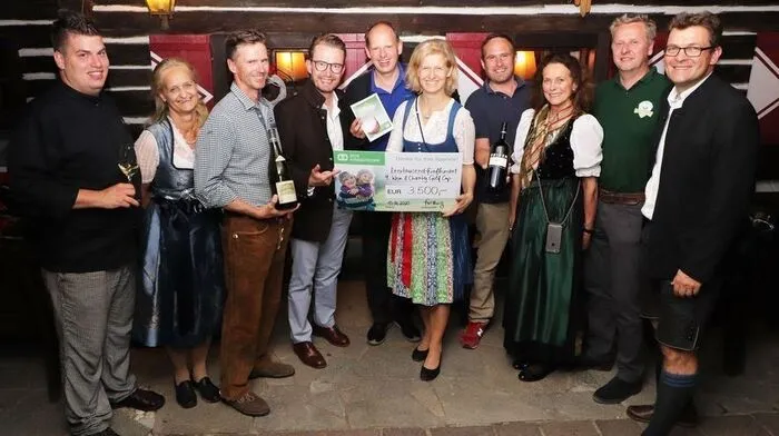 Gruppenbild mit Gastgebern, Partnern, Sponsoren und dem Spendenscheck