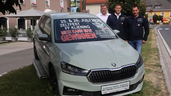 Drei Männer stehen neben einem Auto