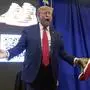 Republican presidential candidate former President Donald Trump holds gold Trump sneakers at Sneaker Con Philadelphia, an event popular among sneaker collectors, in Philadelphia, Saturday, Feb. 17, 2024. (AP Photo/Manuel Balce Ceneta)