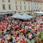Zahlreiche Besucher verfolgen in einer Innenstadt ein Fußballspiel