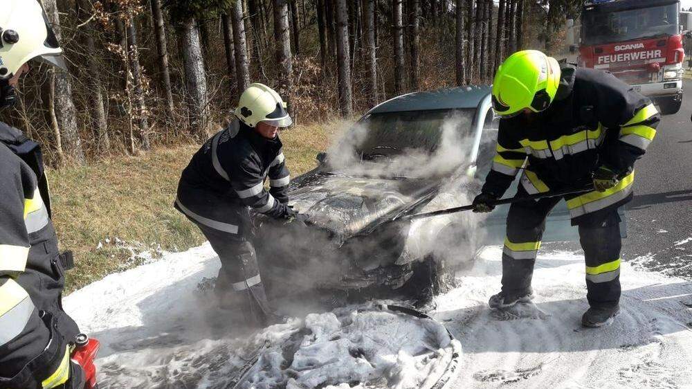Feuerwehrleute löschen Fahrzeugbrand