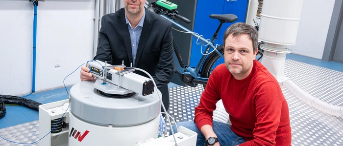 Martin Gossar und Bernhard Fuchs (rechts) testen Fahrrad-Akkus auf einer Rüttelplatte